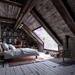 Wood stove in a cozy cabin with a white bed and a large window with snow outside