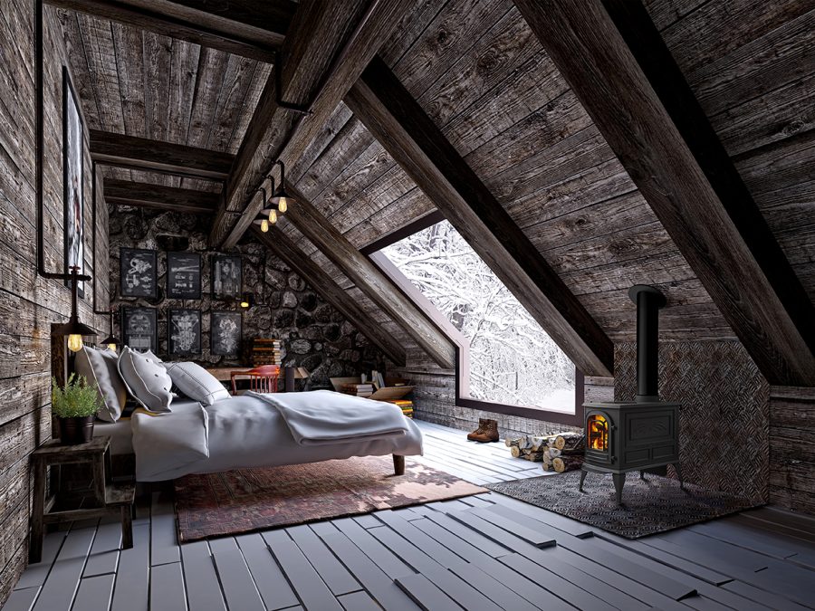 Wood stove in a cozy cabin with a white bed and a large window with snow outside