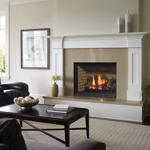 Fireplace insert with glass front and white trim with tan stones in a white living room with black furniture and a window