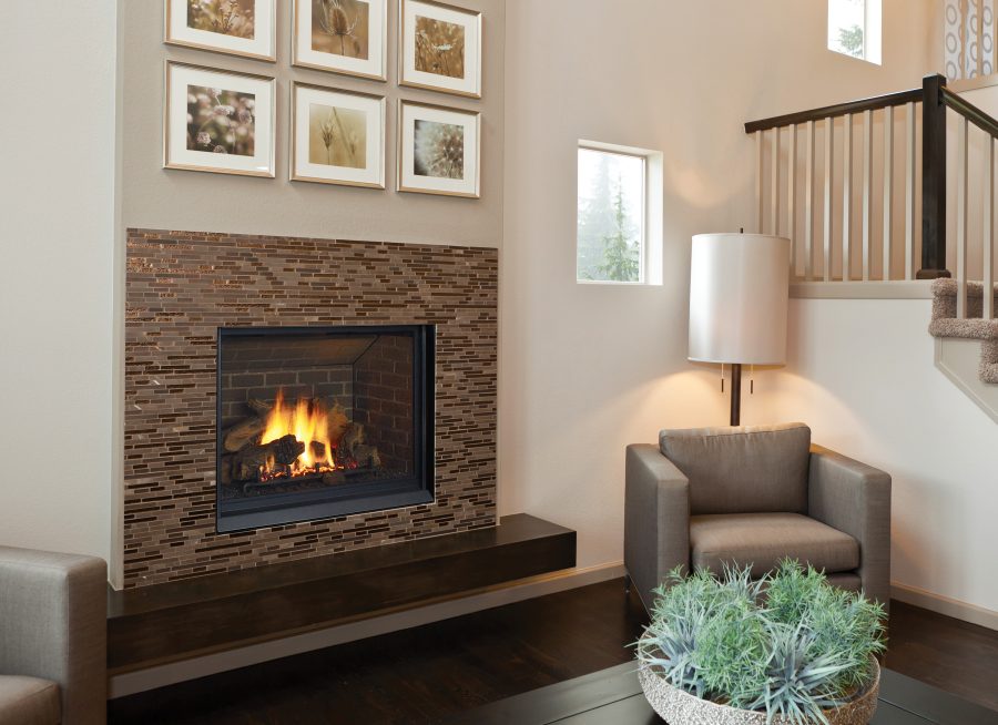 Fireplace insert in a well with brown stone trim and a set of stairs next to it