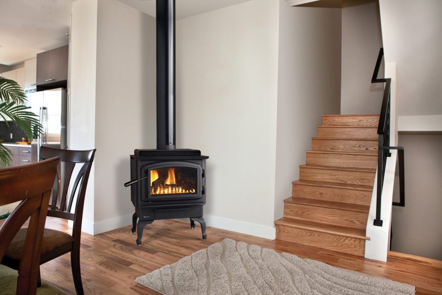 Black stove in the corner of a room simple room with a set of stairs and a some furniture