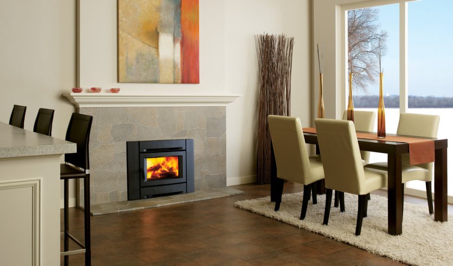 Wood fireplace insert in a modern home with a large window in the background and some seating