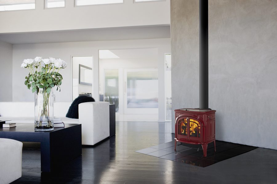 Small red woodstove in a modern home with white walls