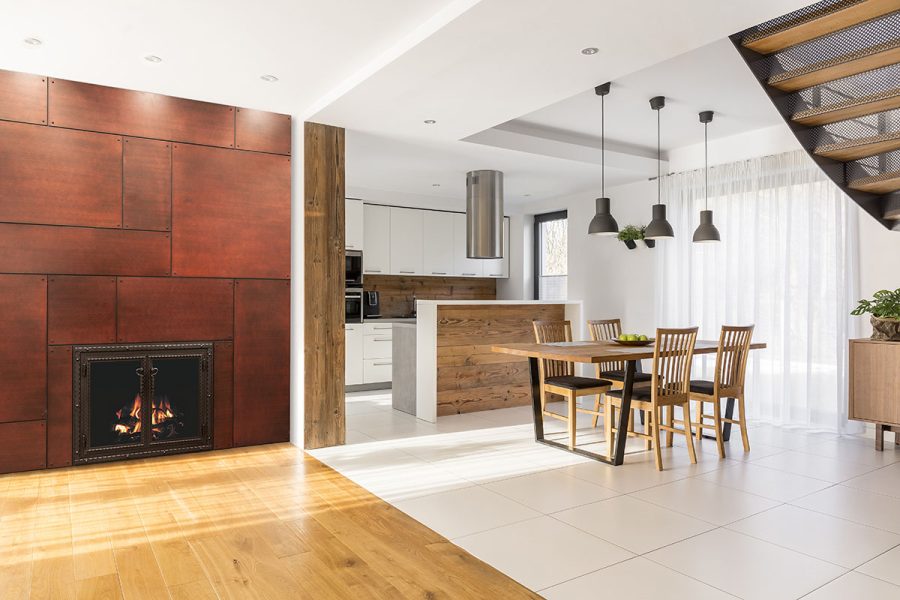 White polished dining room with a fireplace with a bronze steel surround