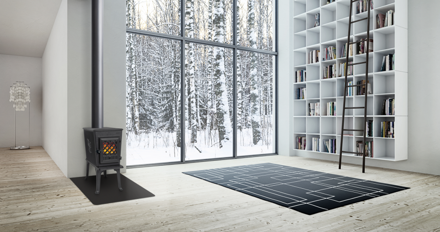 Black wood stove in a fancy contemporary home with a large window wall behind it showing a snowy forest