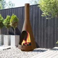 Outdoor fireplace next to a fence with some trees