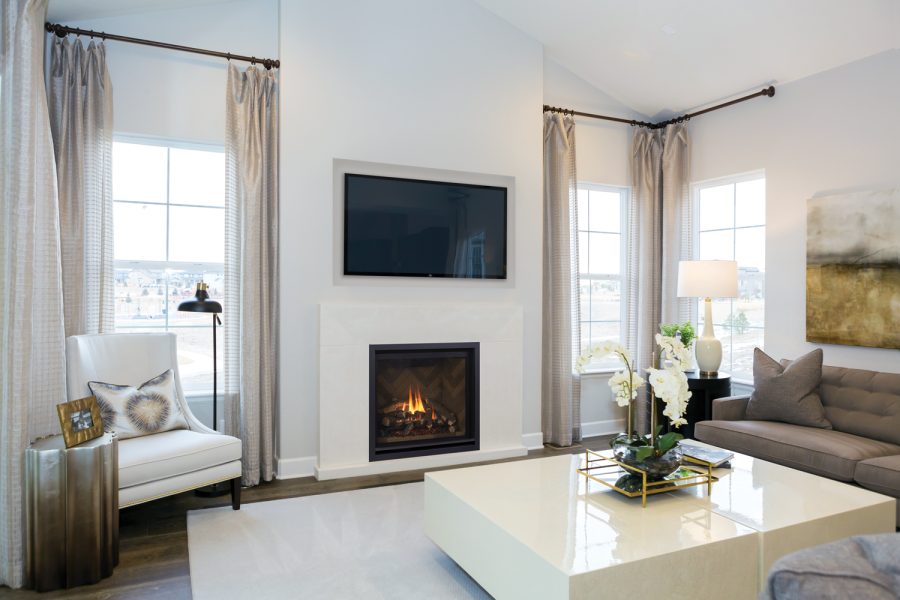 Fireplace insert in a white room with two large windows and a tv