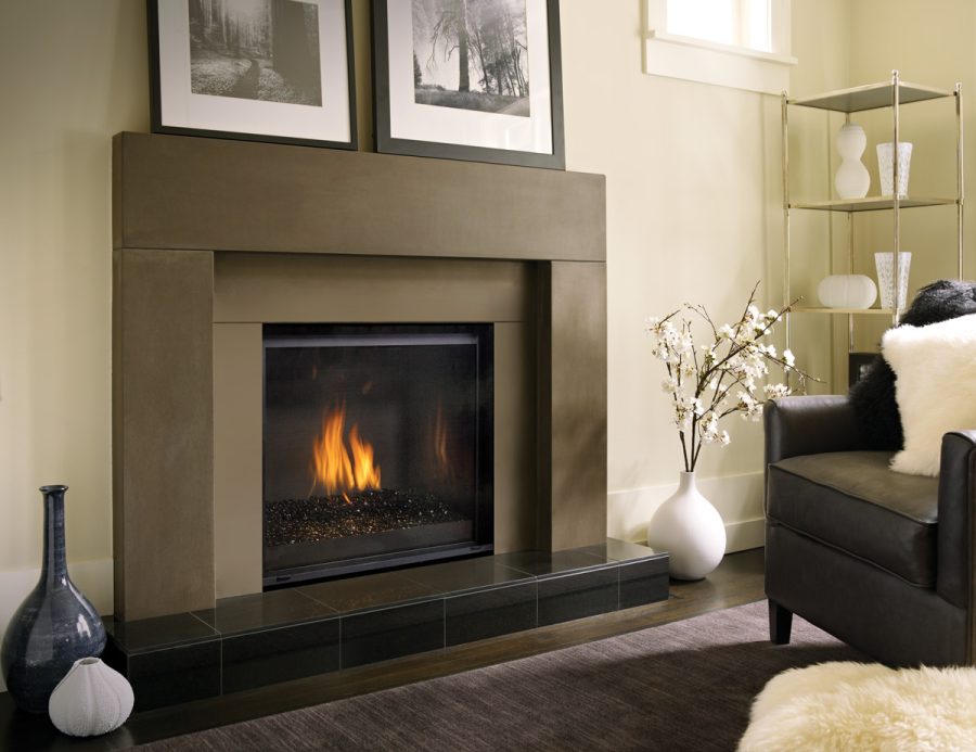 Gas fireplace insert with a black frame and two picture on top of it in a small room with black furniture