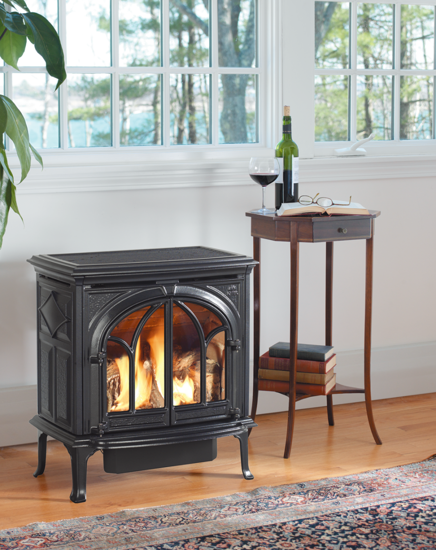 Large window above gas fireplace with a plant next to it