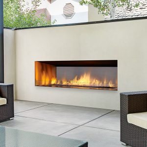 Modern outdoor fireplace insert built with white stone in a seating area with comfortable seating