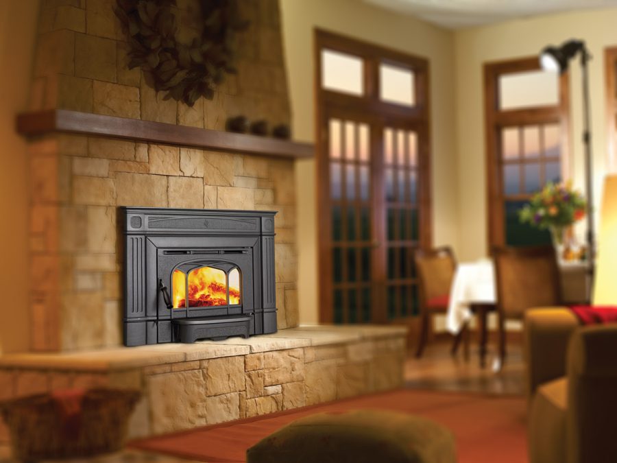 Wood fireplace insert in cozy dining room with large windows in the background