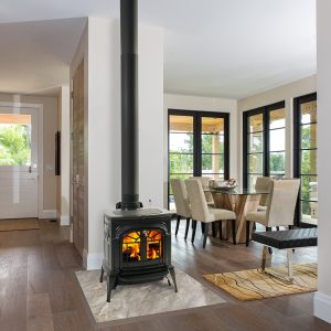 Small wood stove in a nice living room with a dining room in the background