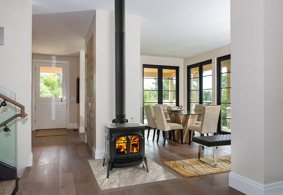 Small wood stove in a nice living room with a dining room in the background