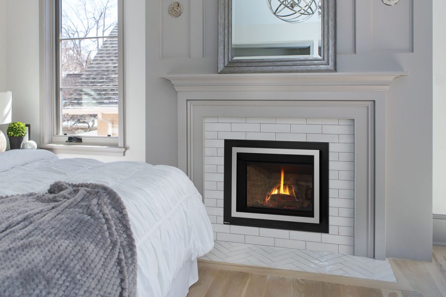 Modern bedroom with white fireplace insert, a window and a mirror above the fireplace