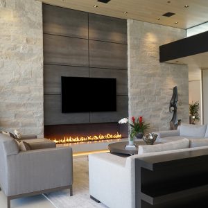 Large fireplace in a modern contemporary home with a tv above it and a seating area