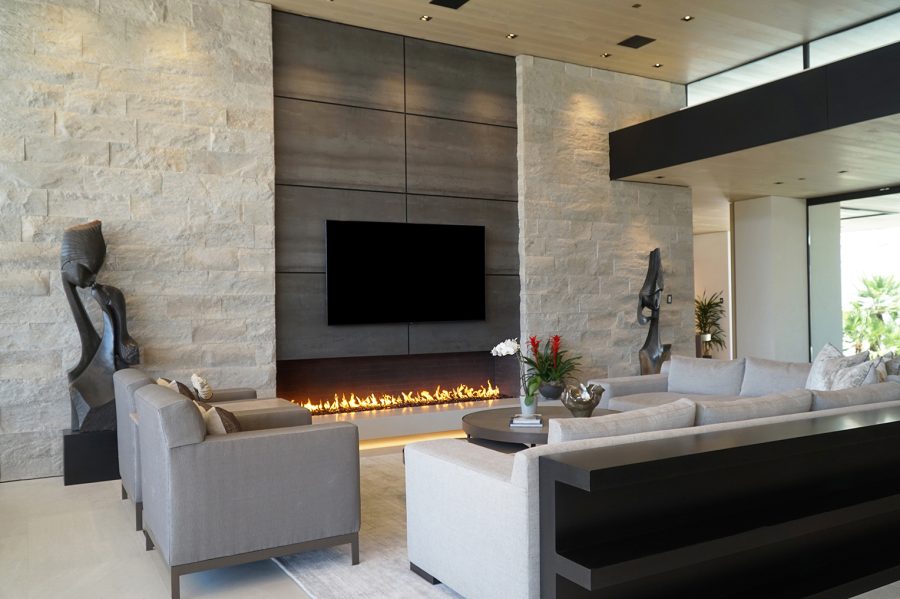 Large fireplace in a modern contemporary home with a tv above it and a seating area