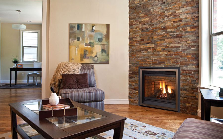 Small gas fireplace insert in a sitting room with a office in the background and a brick surround