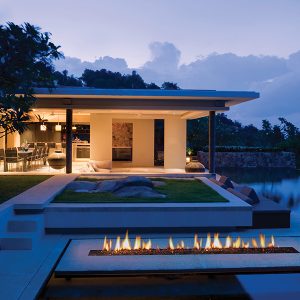 Modern expensive home with a pool and a gas burner fire next to a pool and a seating area