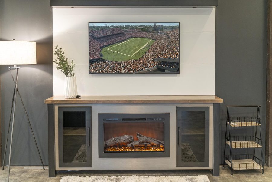 Fireplace with a plant wall above it with a tv mounted on it