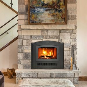 Fireplace insert with stairs behind it and a window