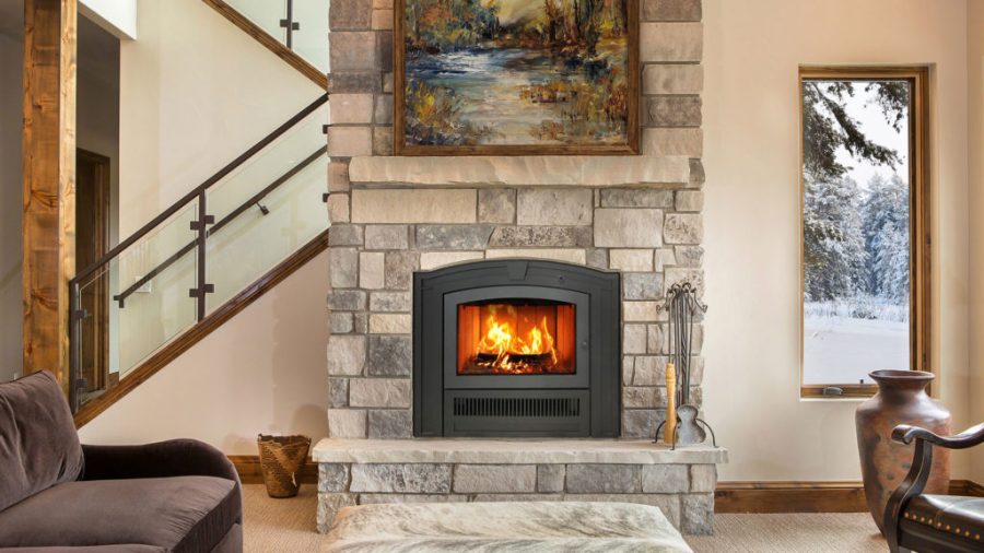 Fireplace insert with stairs behind it and a window