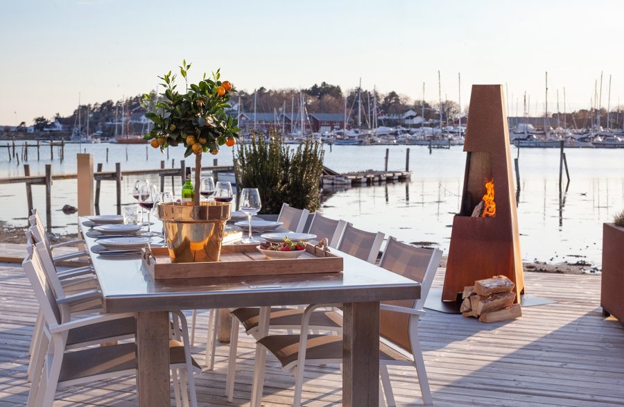 Outdoor wood fireplace on a dock with a table next to it