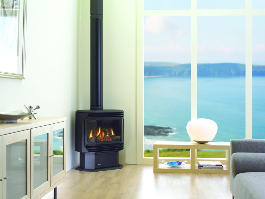 Modern black gas stove in front of large window overlooking the sea