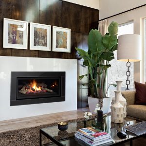 Modern living room with three paintings above a gas fireplace insert with a window in the background