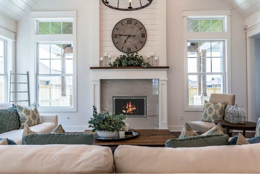 White living room with fireplace and two large windows