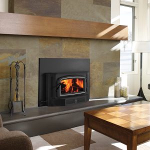 Wood fireplace insert in a modern home with concrete walls and a few large windows