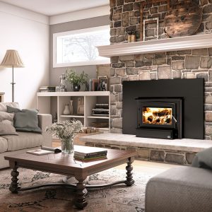 Wood fireplac einsert with warm fire going with some furniture and two windows.