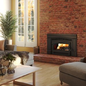 Wood stove inset with a brick surround with windows on either side and a bookshelf with seating