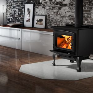 Wood stove with fire going in a living room with wood floors