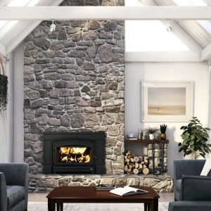 Wood fireplace insert with a stone surround and chimney in a modern living room with open white rafters and large windows