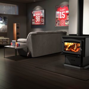 Wood stove in a grey living room with a couch and a tv