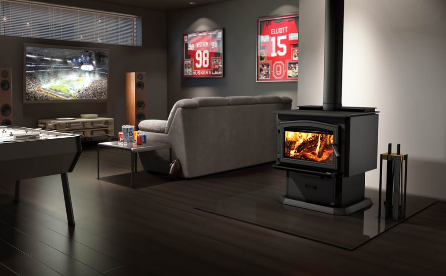 Wood stove in a grey living room with a couch and a tv