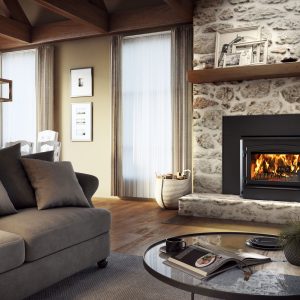 Modern wood fireplace insert with a stone surround in a living room with two windows and some seating