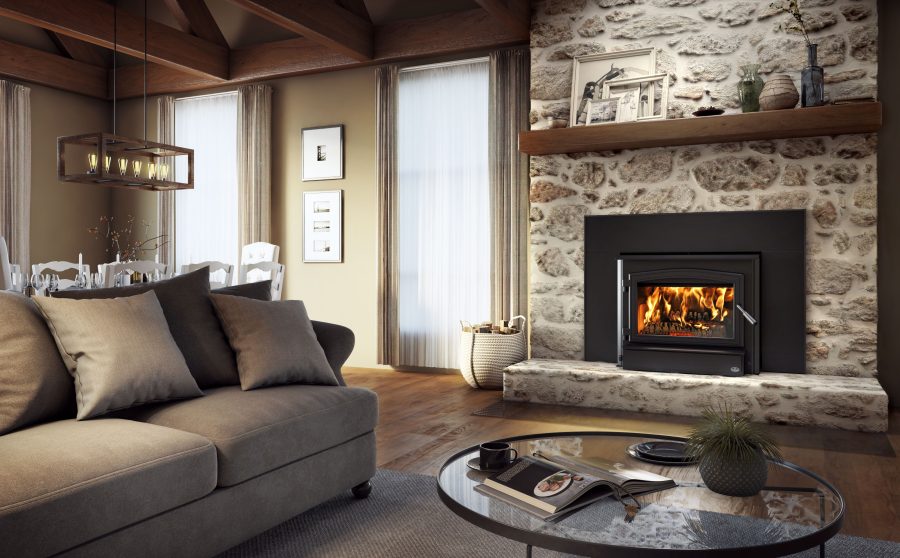 Modern wood fireplace insert with a stone surround in a living room with two windows and some seating